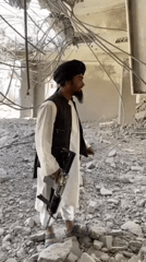 Men survey building damage aftermath in Mandisar, Afghanistan