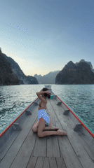Woman sits on longtail boat bow near Khao Phang