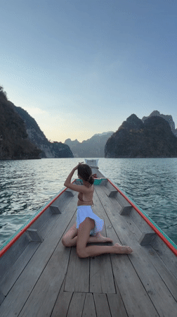 Woman sits on longtail boat bow near Khao Phang