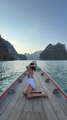 Woman sits on longtail boat bow near Khao Phang