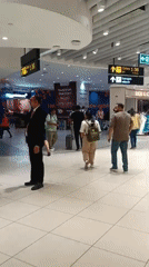 Evening travelers move through busy New Delhi airport terminal