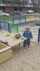 Toddler plays in sandbox with toys in Serpukhov playground
