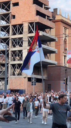 Crowd with Serbian flag crosses Belgrade streets