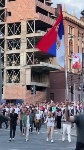 Crowd with Serbian flag crosses Belgrade streets