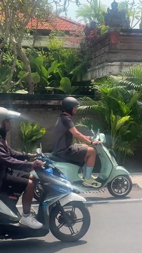 Man rides blue Vespa through Kerobokan streets early morning