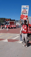 Political campaigners in red gather in Dunnae-myeon street demonstration