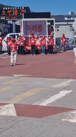 Political campaigners in red gather in Dunnae-myeon street demonstration