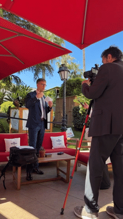 Interview filmed under red umbrella at Cannes resort