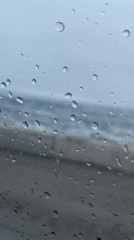 Stormy sea view captured through rain-soaked window in Russia