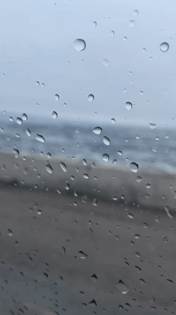 Stormy sea view captured through rain-soaked window in Russia