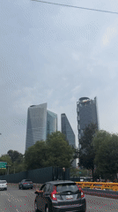 Highway view captures Mexico City skyline under grey skies
