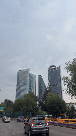 Highway view captures Mexico City skyline under grey skies