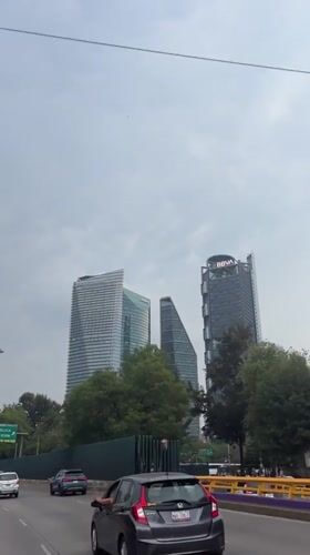 Highway view captures Mexico City skyline under grey skies