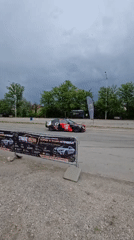 Race car performs donuts on empty road, leaves skid marks