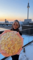 Woman with rose bouquet photographed on Berlin rooftop