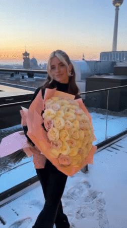 Woman with rose bouquet photographed on Berlin rooftop