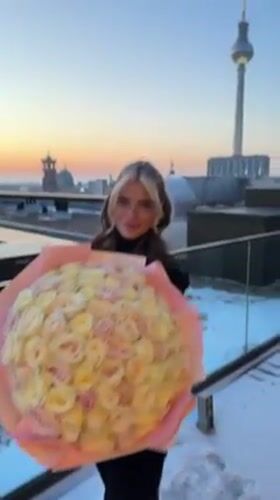 Woman with rose bouquet photographed on Berlin rooftop