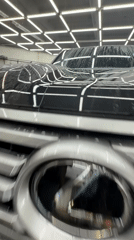 Detail shop polishing a dark blue car in Krasnoyarsk garage
