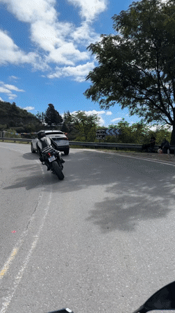Motorcyclist rides winding road followed by SUV in Argentina
