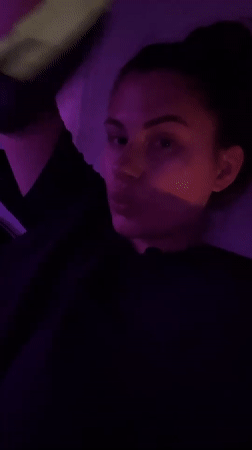 Woman with yellow glove observed in purple-lit Kiryat Bialik residence