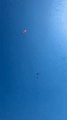 Paragliders and kayakers enjoy a sunny afternoon in Boreti