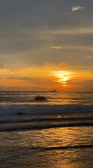 Lone beachgoer watches sunset at Choeng Thale, Thailand
