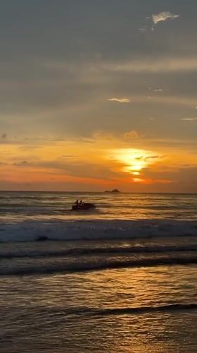 Lone beachgoer watches sunset at Choeng Thale, Thailand