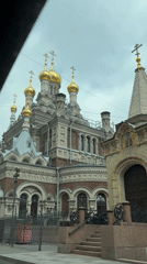 Orthodox church with golden domes filmed from vehicle in Saint Petersburg