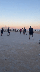 Casual soccer game played near Barcelona beach Tuesday evening