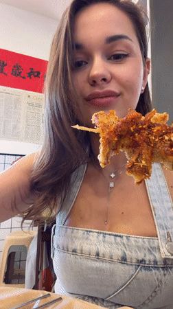 Woman enjoys street food lunch in Beijing's Dongcheng District