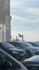 Person sits on billboard framework in Ruse parking lot