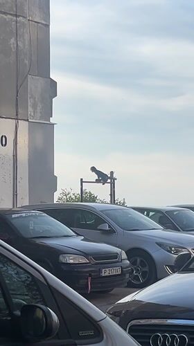 Person sits on billboard framework in Ruse parking lot