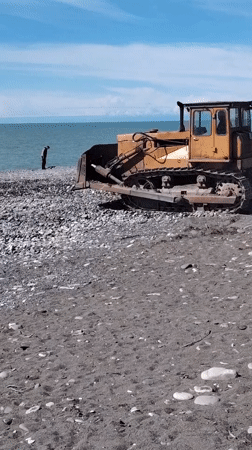 Yellow bulldozer spotted on black sand beach in Batumi