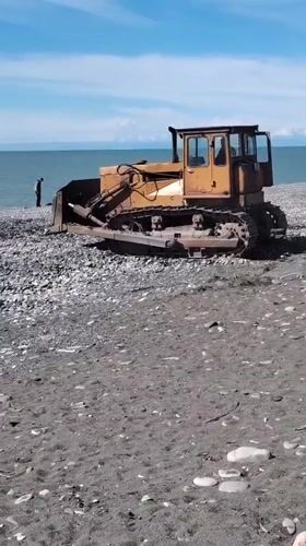 Yellow bulldozer spotted on black sand beach in Batumi
