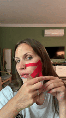 Woman applies therapeutic tape to face in Fethiye