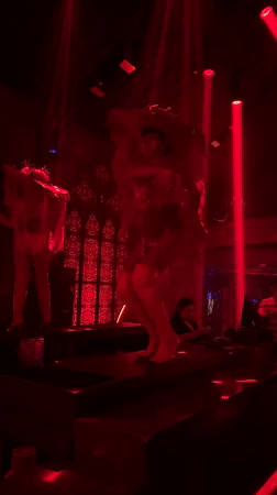 Sequined performers on stage at a red-lit North Kuta club