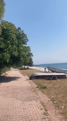 Kemer waterfront: boats, beach, and a flipped Quicksilver hull