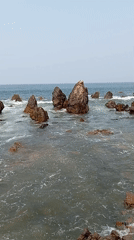 Waves crash against rocks at Arambol shoreline, India