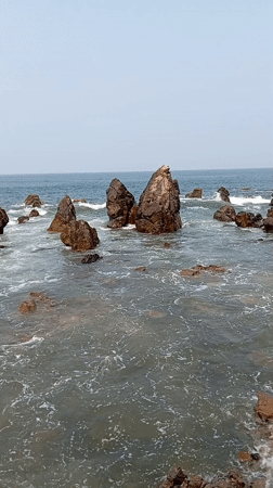 Waves crash against rocks at Arambol shoreline, India