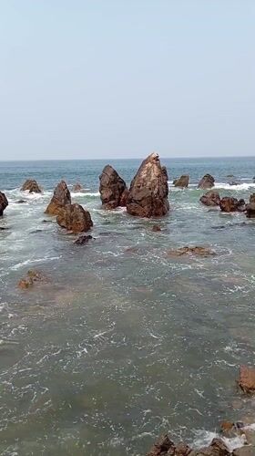 Waves crash against rocks at Arambol shoreline, India