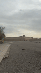 Tourists explore historic Jiayuguan Fortress under overcast skies