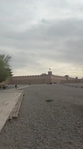 Tourists explore historic Jiayuguan Fortress under overcast skies