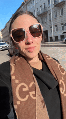 Woman in designer accessories smiles for camera on Saint Petersburg street