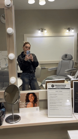 Woman Takes Mirror Selfie in Grey Room