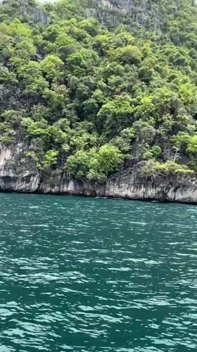 Boat passenger films tropical island off Haad Yao Thailand