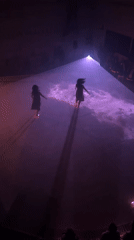 Two dancers perform in purple spotlight on Berlin square