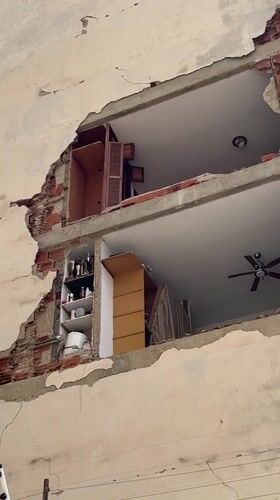 Caracas apartment building shows major facade damage with equipment on site