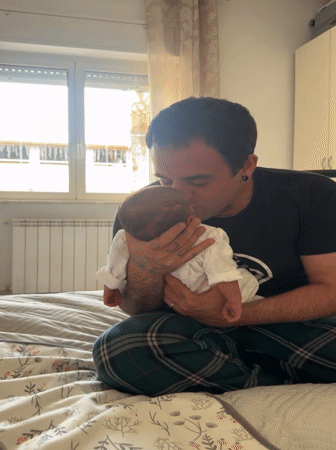 Father tenderly holds newborn baby in Aprilia, Italy