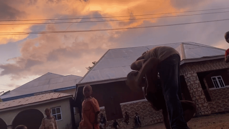 Children play in dirt yard during sunset in Achara