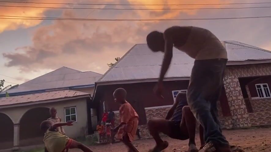 Children play in dirt yard during sunset in Achara